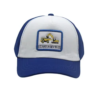 Dettaglio del cappellino blu e bianco con toppa ricamata di un escavatore giallo