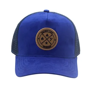Close-up of royal blue suede trucker hat with round leather patch and breathable mesh back