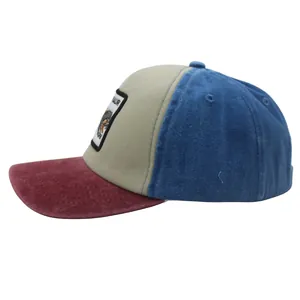 Detail of a color-block kids baseball cap with a dinosaur embroidered patch on the front