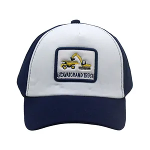 Dettaglio del cappellino bicolore blu e bianco con toppa ricamata di escavatore
