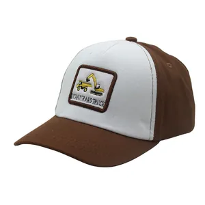 Dettaglio del cappellino per bambini con ricamo di escavatore e design a contrasto marrone bianco