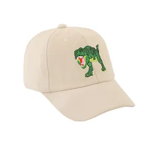 Gros plan sur la broderie dinosaure vert d'une casquette en coton beige de qualité