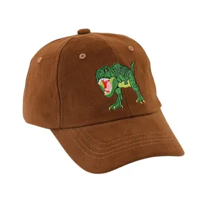Détail d'une casquette marron en coton avec broderie de dinosaure vert et surpiqûres