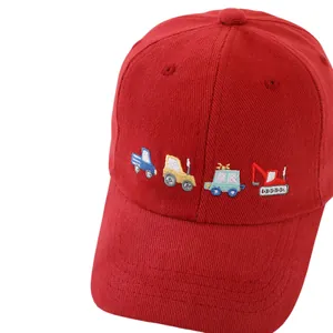 Dettaglio del cappellino rosso per bambini con ricamo di camion colorati in stile cartone