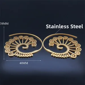Macro detail of bohemian hollow scroll pattern on gold stainless steel earrings