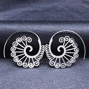 Macro view of spiral hollow carved stainless steel earrings on black leather texture