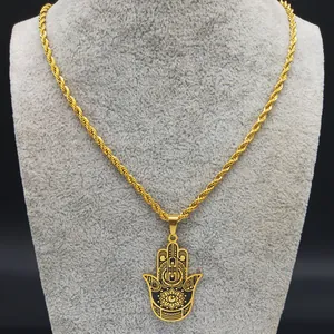 Gros plan du pendentif Main de Fatima en or avec motif Evil Eye sur présentoir gris
