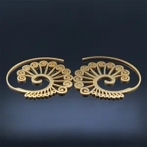 Macro view of gold spiral earrings with hollow floral patterns and vintage ethnic design