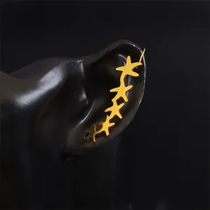 Elegant gold starfish ear crawler featuring five stars along the ear lobe on black background