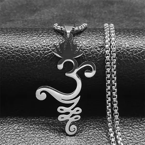 Vue macro du pendentif Om en acier inoxydable argenté sur fond de cuir noir texturé