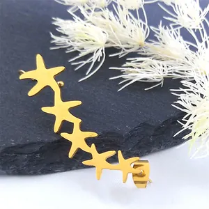 Elegant gold starfish ear crawler earrings in stainless steel on a textured stone background