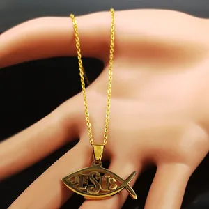Detalle macro del collar con colgante de pez Ichthys dorado y grabado calado de Jesús