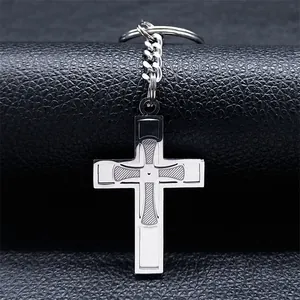 Detailed macro shot of a stainless steel cross keychain with engraved geometric patterns