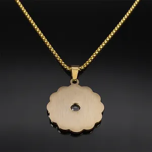Golden flower pendant necklace with brushed metal finish and dark gemstone inlay