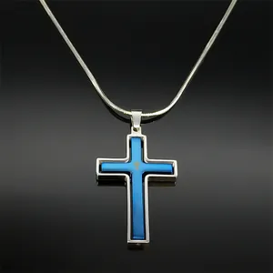 Detalle de un colgante de cruz giratoria con capa azul en una cadena de serpiente plata