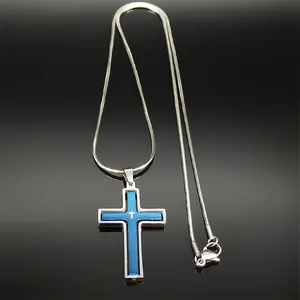 Detalle de un colgante de cruz giratoria azul y plata en una elegante cadena serpiente