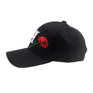 Close-up of black baseball cap with red rose and white letter A embroidery detail