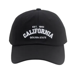 Close-up of white 3D embroidery and durable cotton twill texture on a black baseball cap
