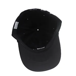 Detail view of the interior polyester lining and washing label of the black baseball cap