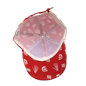 Détail de la casquette rouge en polyester avec motifs de crânes blancs et étiquettes internes