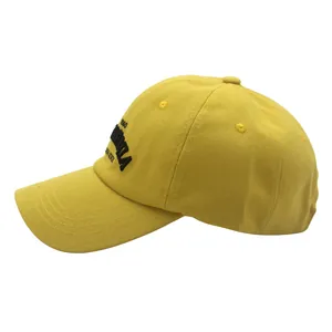 Detail view of ginger yellow cotton baseball cap with black 1850 embroidery on the side
