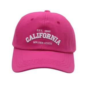 Detailed close-up of white California embroidery on a rose red cotton baseball cap