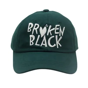 Detail of dark green baseball cap with white BROKEN BLACK letter embroidery and heart