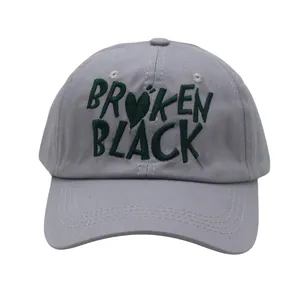 Detail of embroidered 'BROKEN BLACK' text on gray cotton baseball cap crown