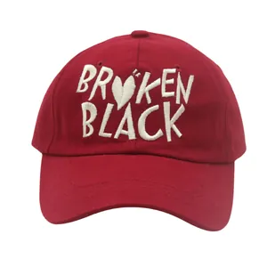 Detail view of white Broken Black embroidery and heart pattern on red cotton baseball cap