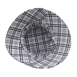 Detail view of the black and gray plaid pattern and stitching on a reversible sun hat