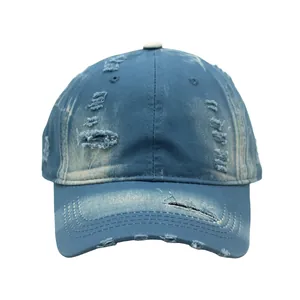 Close-up of distressed blue washed denim baseball cap with vintage frayed hole details