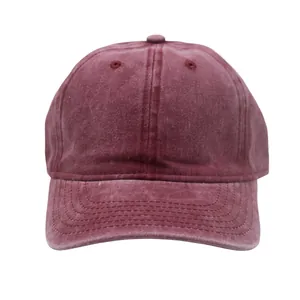 Close-up of washed burgundy cotton baseball cap showing vintage distressed fabric texture