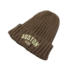 Détail de la broderie BOSTON 1630 sur un bonnet en maille côtelée marron pour bébé