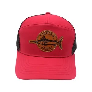 Detailaufnahme einer roten Trucker-Cap mit einem braunen Leder-Patch und Schwertfisch-Gravur