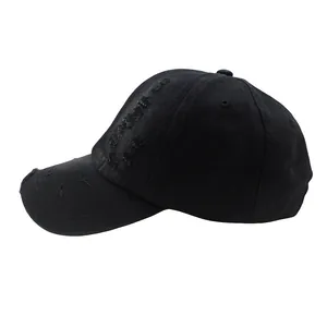 Detailed shot of distressed cotton fabric and frayed holes on a vintage black baseball cap