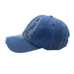 Detail of distressed navy blue baseball cap showing torn fabric and vintage washed canvas texture