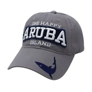 Close-up of gray baseball cap with white ARUBA embroidery and a blue shark on the brim