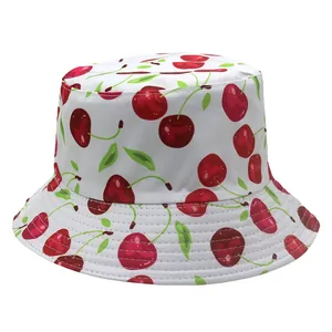 Close-up of white cotton bucket hat with vibrant red cherry print and decorative stitching