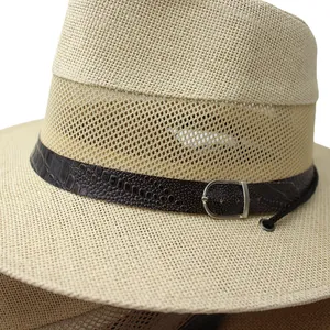 Close-up of beige straw hat featuring breathable mesh detail and brown leather strap