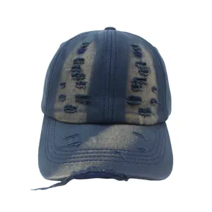 Detailed view of the vintage distressed holes and frayed edges on navy blue washed cotton cap