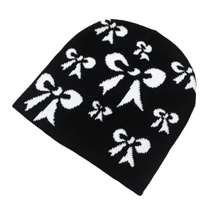 Gros plan sur les motifs de nœuds blancs tissés d'un bonnet noir en maille de qualité