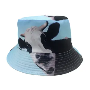 Detail view of the light blue bucket hat featuring a realistic black and white cow print texture
