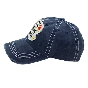 Detail of distressed navy denim baseball cap with DOG vibes only patch embroidery