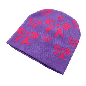 Gros plan du bonnet en tricot violet avec jolis motifs de nœuds roses en jacquard