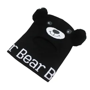 Dettaglio del passamontagna in maglia per bambini con motivo orso e pompon in peluche
