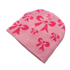 Vue détaillée du bonnet en tricot rose avec motif jacquard de nœuds rose vif soigné