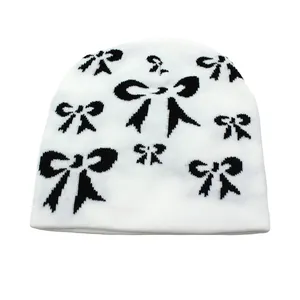 Texture de tricot détaillée du bonnet blanc avec motif jacquard à nœuds noirs d'hiver