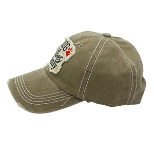 Detail of khaki cotton baseball cap with DOG patch embroidery and distressed stitching