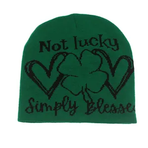 Green knit beanie with black Lucky and Blessed slogan and clover pattern for winter warmth