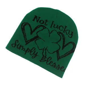 Detail of green knit beanie featuring lucky clover pattern and blessed jacquard text